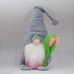 Close-up of plush gnome figurine holding pink tulips for Mother's Day home decoration