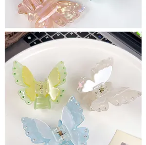 Detail of four colorful acrylic butterfly hair claws with rhinestones on a white plate