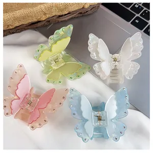 Detailed macro view of four pastel acrylic butterfly hair claws with rhinestone edges