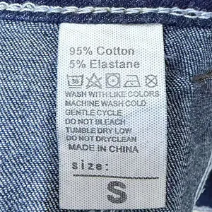 Dettaglio dell'etichetta con composizione 95% cotone sui pantaloncini di jeans denim