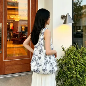 Detailed view of a white plush shoulder bag featuring a blue butterfly pattern.