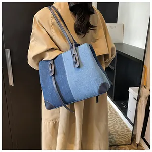 Large capacity denim patchwork tote bag with leather straps worn by model on shoulder