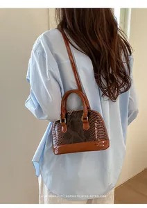 Minimalist snakeskin pattern shell bag shown as a crossbody on a model's back