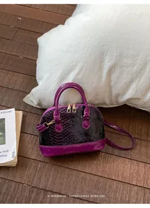 Detail of purple shell bag with snake pattern leather and glossy patent finish