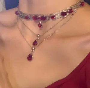 Detail of multilayer choker with silver mesh and dark red zircon teardrop pendants