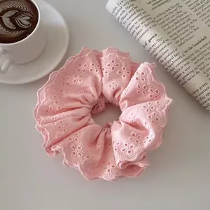 Close-up of pink floral lace scrunchie with hollow embroidery and layered ruffles