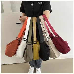 Modell hält Nylon-Halbmondtaschen in verschiedenen Farben in einer fächerförmigen Anordnung