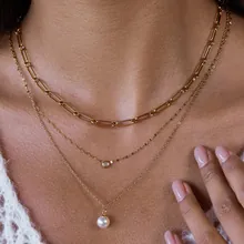 Collana dorata a tre strati con catena a graffetta, ciondolo in zircone e perla bianca