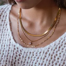 Dettaglio di una collana a tre strati in acciaio inossidabile dorato con pendente in zircone