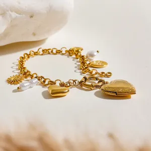 Dettaglio del bracciale con medaglione a cuore dorato, perle barocche e monete