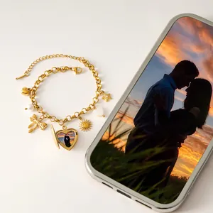 Dettaglio di un braccialetto dorato con ciondolo a cuore personalizzabile e perline
