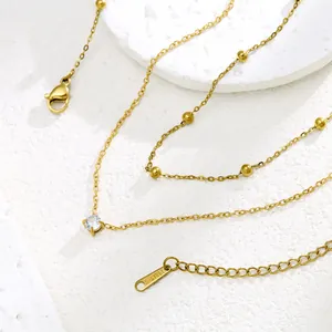 Double-layer gold stainless steel necklace with small beads and a sparkling zircon pendant