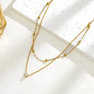 Double-layered gold titanium steel necklace with small beads and a single zircon pendant