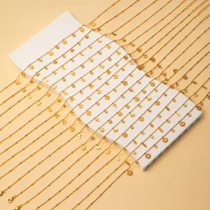 Detail of gold-plated stainless steel necklaces with various geometric pendants and crystals