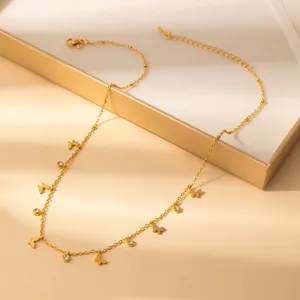 Detail view of a gold butterfly necklace with zircon pendants on a luxury display box