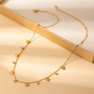 Detailed macro view of gold-plated heart charms and cubic zirconia on a delicate chain necklace