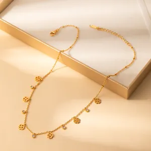 Close-up of gold clover necklace with hollow petals and small crystal charms