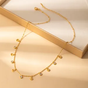 Detailed shot of golden anchor pendants and zircon charms on a stainless steel chain