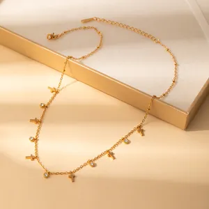 Detail of gold petal necklace featuring crystal zircons and cross charms on jewelry box