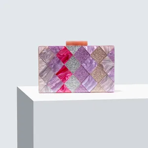 Close-up of geometric acrylic evening bag with purple marble texture and glitter panels