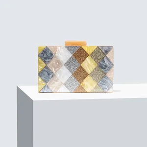 Detail of geometric acrylic evening bag with marble patterns and diamond patchwork design