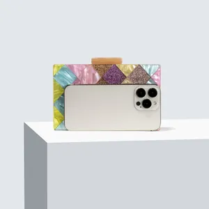 Detail of acrylic clutch bag with rainbow geometric patterns and marble textured twist lock