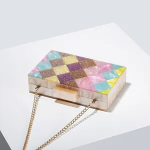 Detail of acrylic evening clutch with marble texture and colorful glitter patchwork