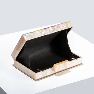 Macro view of pearlescent ivory acrylic clutch with colorful stripes and black lining