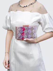 Detail of acrylic clutch with purple and pink harlequin pattern for evening parties