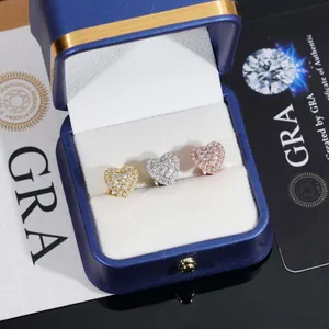 Détail de boucles d'oreilles cœur en moissanite en finitions or, argent et or rose avec écrin