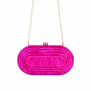 Detail of rose pink acrylic evening clutch with marble texture and gold chain strap