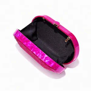 Detailed interior of fuchsia marble acrylic clutch with gold hardware and black lining