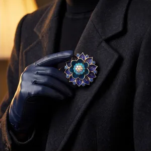 Luxuriöse blaue Lotus-Brosche mit Kristallblüten auf einem Wollmantel gesteckt
