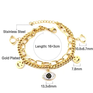 Detail of gold-plated stainless steel bracelet featuring evil eye and smiley charms