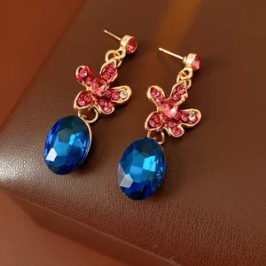 Elegant gold earrings with blue crystal drops and pink floral stones for evening wear