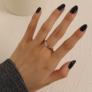 Detailed view of rose gold four-prong ring with a round cubic zirconia on hand