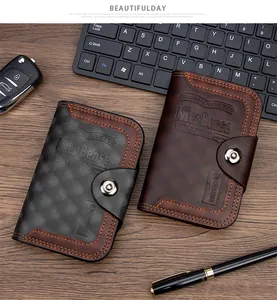 Detalle de carteras de cuero PU para hombre con relieve y cierres metálicos en un escritorio