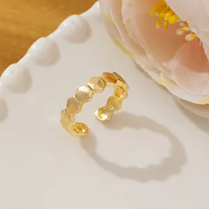 Detailed view of gold hexagon honeycomb ring featuring a polished open adjustable design