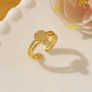 Close-up of gold Hamsa ring with white zircons on a minimalist white ceramic plate