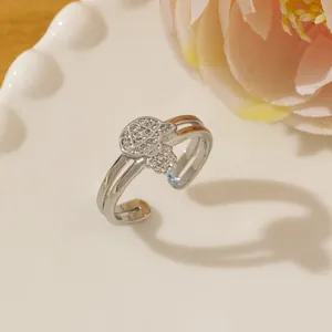 Close-up of silver adjustable ring with micro-paved crystals on double-band floral design