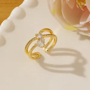 Detail of gold crossover ring with micro-pave diamonds and heart-shaped zircon detail