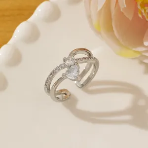 Close-up of silver ring with double-layered band, heart and round zircon stones