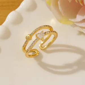 Detail of double-layer gold ring with heart zircon and pavé crystals on a ceramic tray