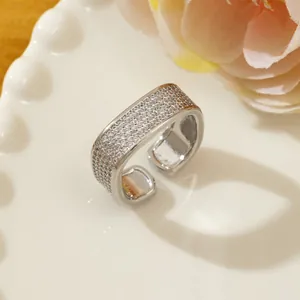 Close-up of adjustable silver pavé ring with shimmering crystals on white tray
