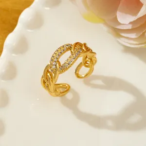 Detail of gold chain link ring with micro-paved rhinestones on a ceramic dish