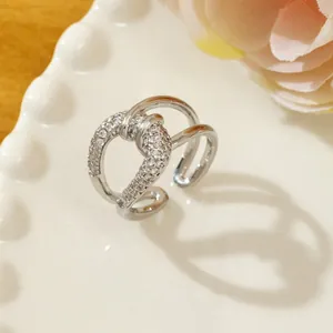 Macro shot of silver twisted ring with pavé-set crystals on white ceramic plate