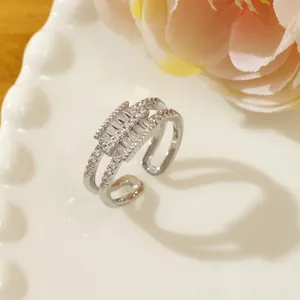 Macro view of double-layer silver ring featuring baguette-cut zircon stones and micro-pave