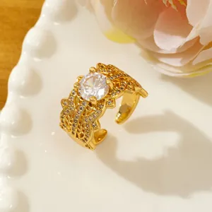 Close-up of a vintage-style gold ring with white zircon and intricate openwork details