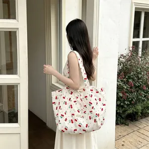 Detail of floral canvas tote bag showing cherry print and tied ribbon closure