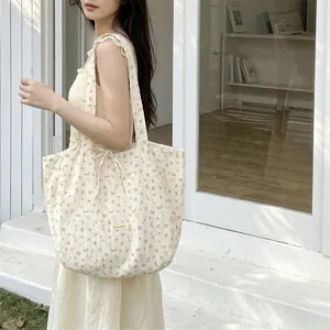 Close-up of floral chiffon tote bag featuring side bow detail and Sezakka brand label